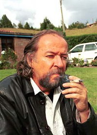 Fernando Rendón fuma un "tabaquito" frente a su mansión de El Retiro en Medellín, al lado de su cuatro puertas blanco nórdico.